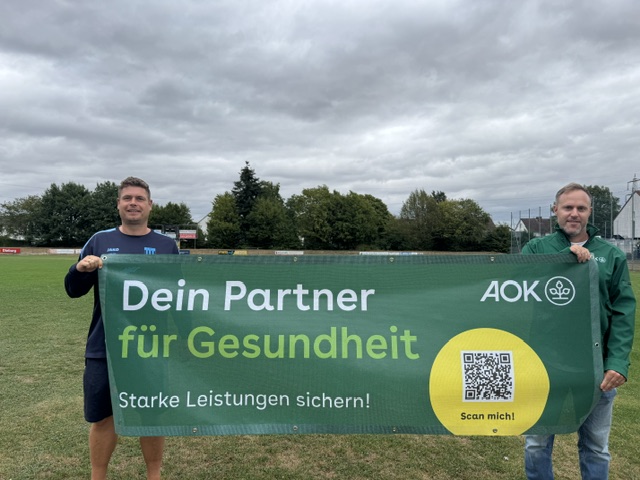 Vertreter des SC Hassia Dieburg und der AOK Hessen halten das Banner Dein Partner für Gesundheit